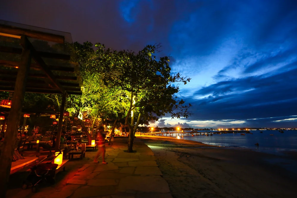 Porto da Barra em Búzios ao anoitecer, com restaurantes iluminados junto à água